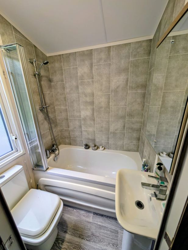 En-suite bathroom with bath, shower screen, toilet and basin