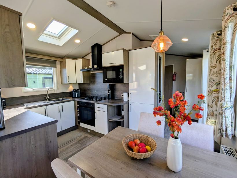Fitted kitchen with gas hob, oven, microwave and tall fridge freezer