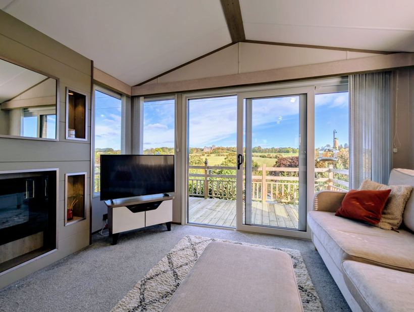 Lounge looking out through patio doors to the deck and parkland