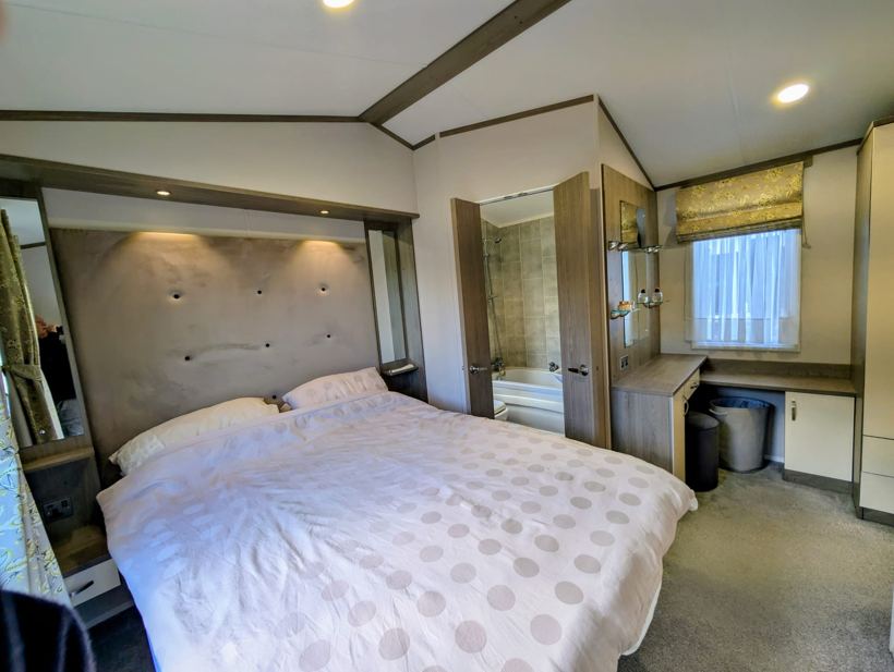 Master bedroom with king-size bed, upholstered headboard and dressing table